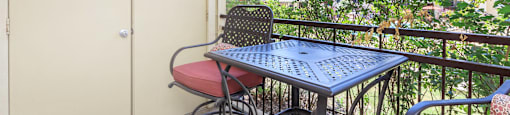 a patio with a table and chairs on the balcony