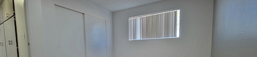 a bedroom with a closet and a window at Villa La Paz Apartments, California, 90706