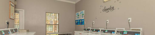 A laundry room with washers and dryers at The Villages at Lost Creek Apartments, Texas