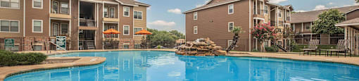 A large swimming pool in front of apartment buildings at The Villages at Lost Creek Apartments, San Antonio, TX, 78247