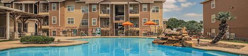 A large swimming pool in front of apartment buildings at The Villages at Lost Creek Apartments, San Antonio