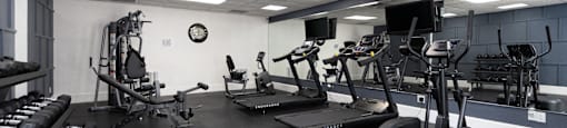 a gym with cardio machines and weights on the floor at Saratoga Resort Villa Apartments, Kissimmee, Florida,  34746