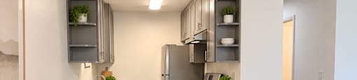 A kitchen with a table and chairs in the foreground and a refrigerator in the background.