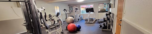 a gym with cardio equipment and exercise balls on the floor at Villa La Paz Apartments, California, 90706