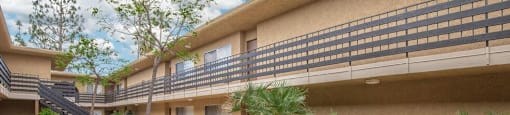 a patio outside of a building with a table and chairs at Villa La Paz Apartments, Bellflower