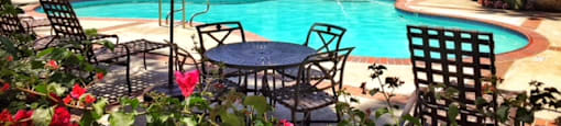 a swimming pool in front of a house with a pool table and umbrella at Victoria Springs, Riverside California