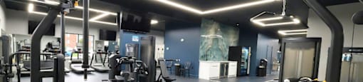 A gym with a variety of equipment and a bench.