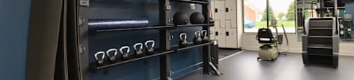 A gym with a blue wall and a rack of weights.