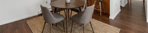 A dining room with a table and chairs.