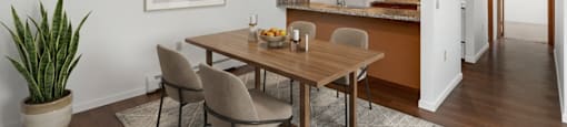A dining room with a wooden table and chairs.
