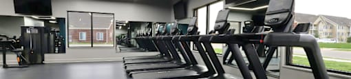 A gym with treadmills and a television.
