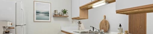 A kitchen with white appliances and wooden accents.