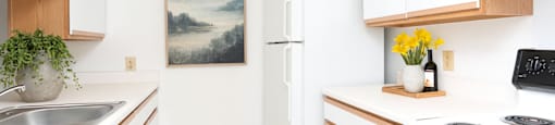 A kitchen with white cabinets and a painting on the wall.
