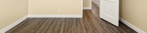 a empty room with wood floors and a white door