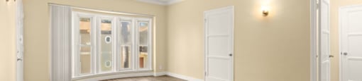 the living room of an empty home with wood floors and doors