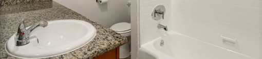 A bathroom with a sink, toilet, and bathtub.
