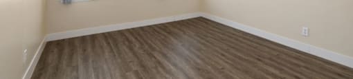 an empty room with two windows and a ceiling fan