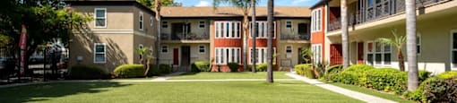 A sunny day at a residential complex with palm trees and well-maintained lawns.