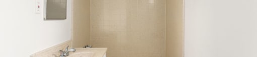 A small bathroom with a white tub and sink.