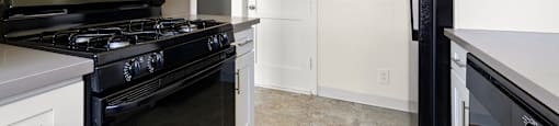 a renovated kitchen with black appliances and white cabinets and a black refrigerator