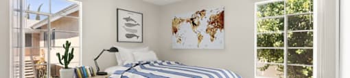 A bedroom with a large bed and a world map on the wall.