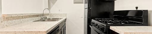 a kitchen with a stove refrigerator and sink
