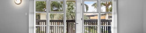 an empty living room with sliding glass doors to a balcony