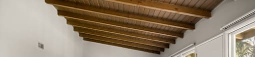 A room with a wooden ceiling and carpeted floor.