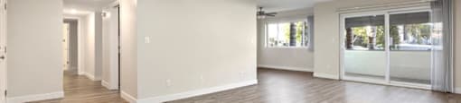 Encino Apartments For Rent - White Oak Terrace - Interior View Of Livingroom Featuring Recess Lights, Large Windows And Wooden Flooring Adjacent To Hallway And Kitchen