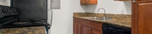 a kitchen with granite counter tops and black appliances