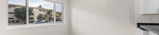an empty living room with a ceiling fan and a window