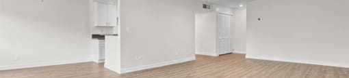 the living room and kitchen of an empty house with a ceiling fan