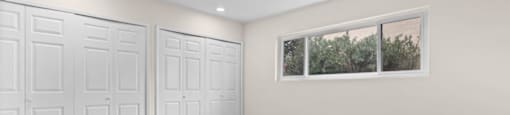 an empty room with three closets and a window