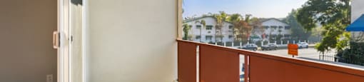 A balcony with a white door and orange railing.