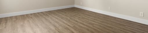 A room with a window and wooden flooring.