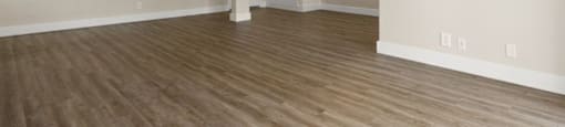 Empty room with wooden flooring and a ceiling fan.