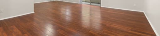 A room with wooden flooring and a sliding glass door.