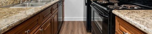 a kitchen with wood cabinets and black appliances at Lombardi Apartments, Woodland Hills, CA, 91367