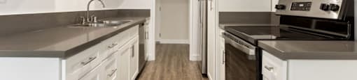 a kitchen with white cabinets and stainless steel appliances at Lombardi Apartments, Woodland Hills, California