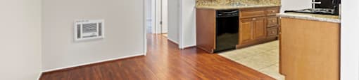 a kitchen with wood floors and white walls