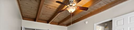 a bedroom with a ceiling fan and a washer and dryer
