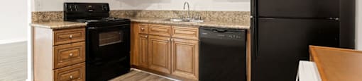 a kitchen with black appliances and wooden cabinets