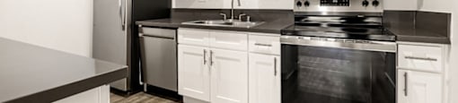 A kitchen with white cabinets at The Reserve at Warner Center Apartments, Woodland Hills, CA