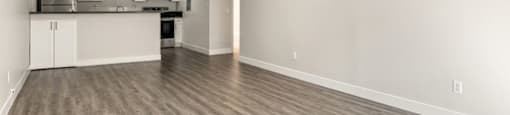 A spacious kitchen with white cabinets and a wooden floor at The Reserve at Warner Center Apartments, Woodland Hills