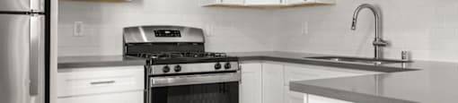 A modern kitchen with a stainless steel refrigerator, oven, and microwave.