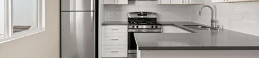 A modern kitchen with stainless steel appliances and white cabinets.