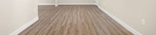A room with wooden flooring and white walls.