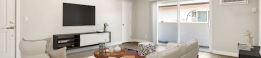 A modern living room with a white sofa and a television.