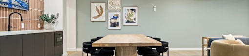 a dining room with a wooden table and black chairs
