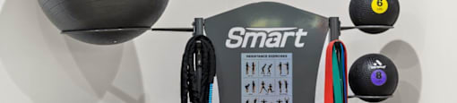 a workout room with two balls and a weight machine